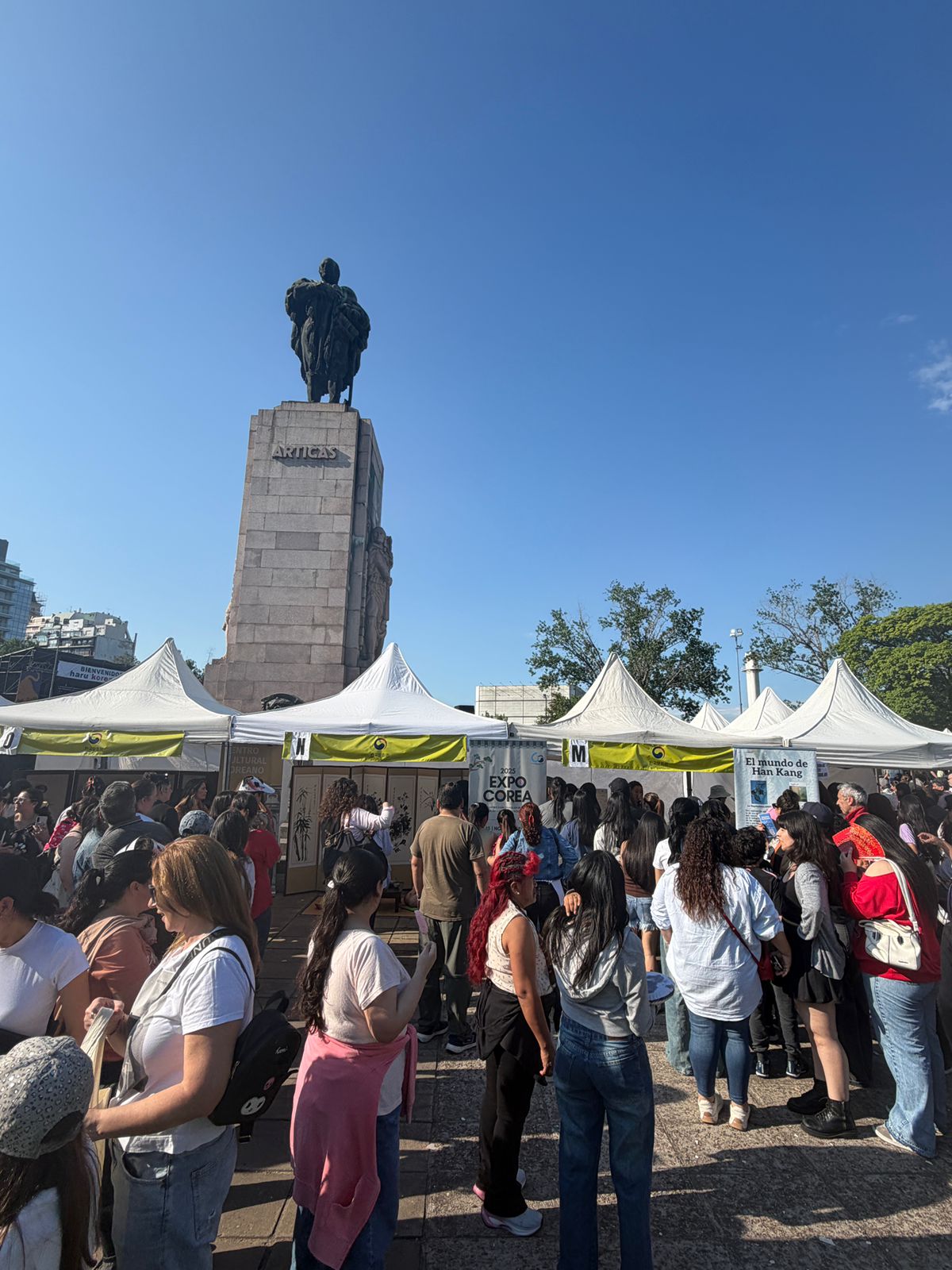 야외 공원 부스 앞에 모여있는 사람들