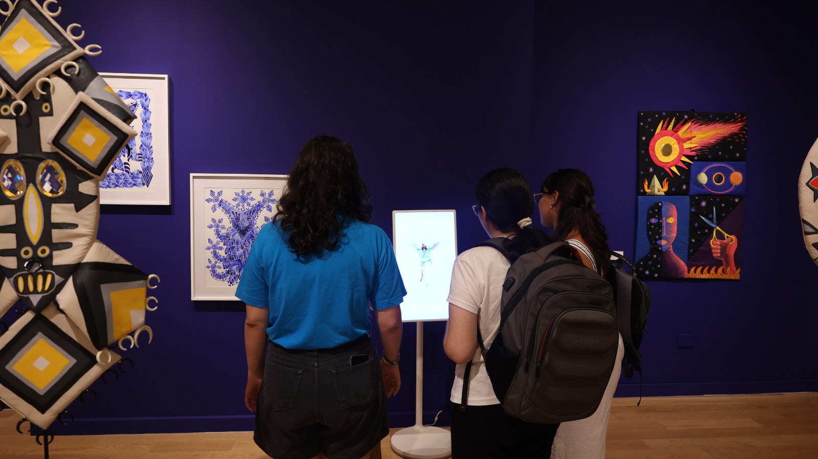 예술품을 구경하고있는 세 여성의 뒷모습